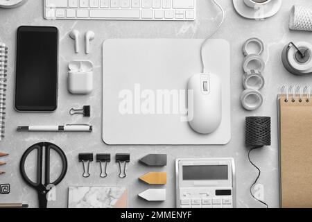 Flat lay composition with wired computer mouse and stationery on light grey table. Space for text Stock Photo