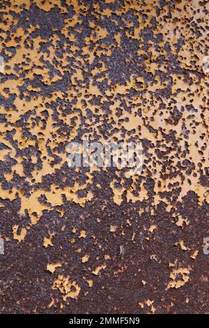 Close up of rusted yellow sheet of metal from abandoned machinery found outdoors. Stock Photo