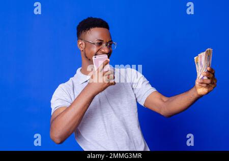 young african businessman holding a lot of money and using his phone Stock Photo