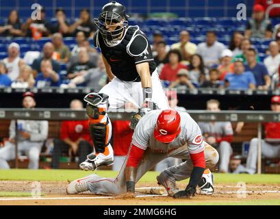 Wearing a monkey mask, Miami Marlins' Miguel Rojas, top, prepares to hit  J.T. Realmuto with a shaving cream pie as Realmuto does a postgame  interview after a baseball game against the Atlanta