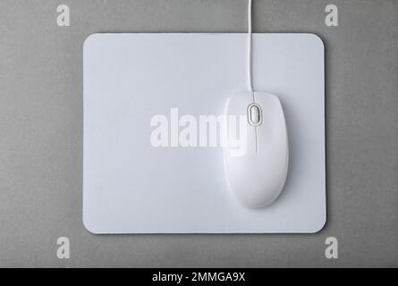 Wired computer mouse and pad on grey background, flat lay Stock Photo