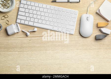 Flat lay composition with wired computer mouse and keyboard on  wooden table. Space for text Stock Photo