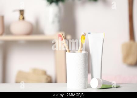 Bamboo toothbrushes and paste on light table indoors. Space for text Stock Photo