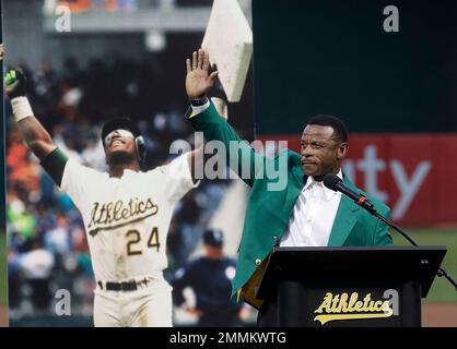 Oakland Athletics' 40th anniversary team top vote-getter Rickey Henderson,  right, throws out the ceremonial first pitch before the A's baseball game  against the Seattle Mariners in Oakland, Calif., Sunday, Sept. 21, 2008.