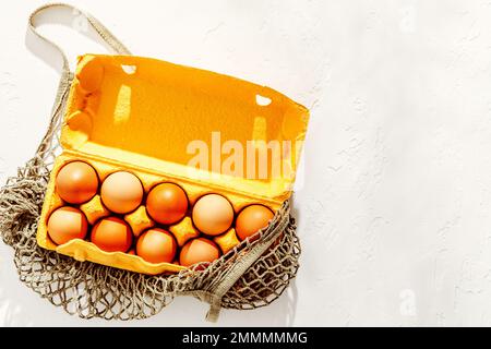 Chicken eggs in recycled cardboard tray with copy space on white texture Stock Photo