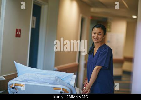 Its ready for the next patient. Cropped portrait of a female nurse standing beside a hospital bed. Stock Photo