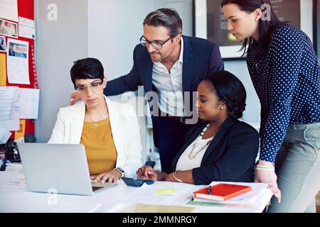 Working together to achieve success. four business colleagues working in the office. Stock Photo