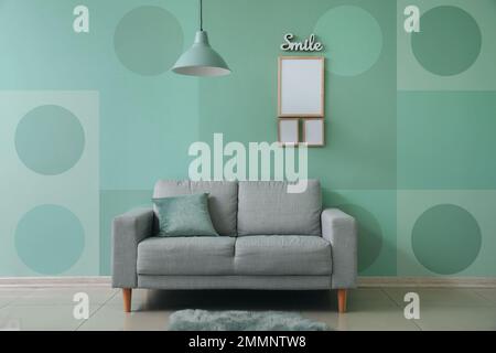 Interior of modern room with sofa near mint wall Stock Photo