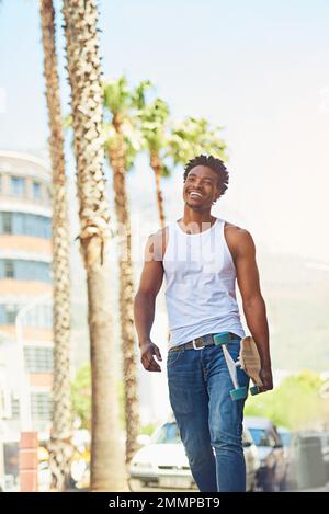 On the lookout for an awesome skating spot. a young skater going for a walk through the city. Stock Photo