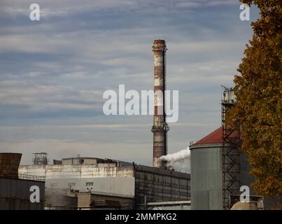 Industrial building with chimneys near the road in autumn. Stock Photo