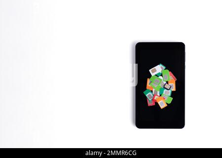 Heap of assorted used sim cards for cellular communication on a cell phone on a white background, copy space. Cellular communication concept. Stock Photo