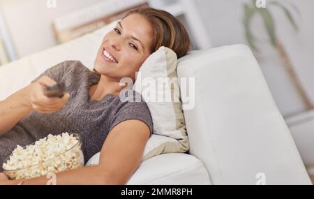 Movie night is the best way to spend me time. a young woman spending a relaxing weekend at home watching tv. Stock Photo