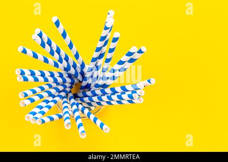 Paper straws for drinks on a yellow background, top view. Stock Photo