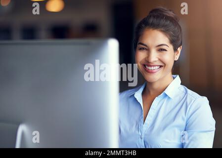 Tackling her work with a can-do attitude. Portrait of a young businesswoman sitting at her office computer. Stock Photo