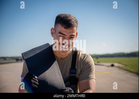 Airman First Class Juan Mejia, 86th Civil Engineer Squadron electrical power production apprentice, carries nylon tape for the Barrier Arresting Kit-12 during the system overhaul at Ramstein Air Base, Germany, Sept. 22, 2022. The system acts as a mechanical barrier capable of rapidly decelerating any landing aircraft with a tail hook. Stock Photo