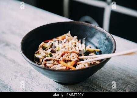 View osf asian noodles udon with pork close-up in a bowl on the table Stock Photo