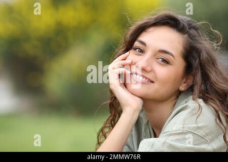 Portrait of a beautiful woman smiling at you in a park Stock Photo