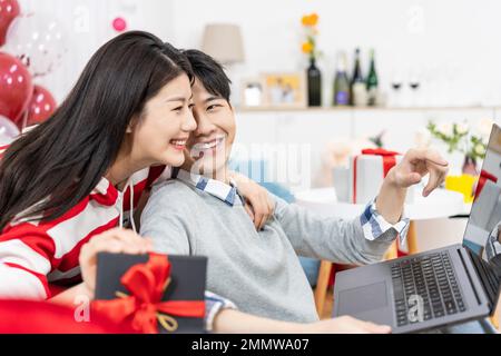 Young couples using laptop at home Stock Photo