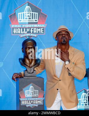 Former NFL player Brian Dawkins, right, poses with a bust of himself and  presenter, former teammate Troy Vincent, during an induction ceremony at  the Pro Football Hall of Fame, Saturday, Aug. 4,