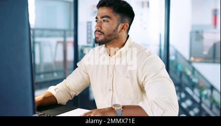 Computer, research and businessman working on a project, report or document in his modern office. Technology, professional and Indian male employee Stock Photo