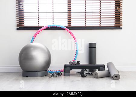 Different sports equipment near window in gym Stock Photo