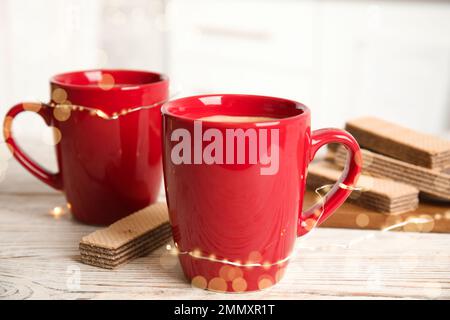 Breakfast with delicious wafer and cups of coffee on white wooden table Stock Photo