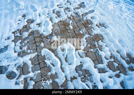 Paving paths in the park, covered with the first snow in winter. Winter weather or first snow concept. Stock Photo