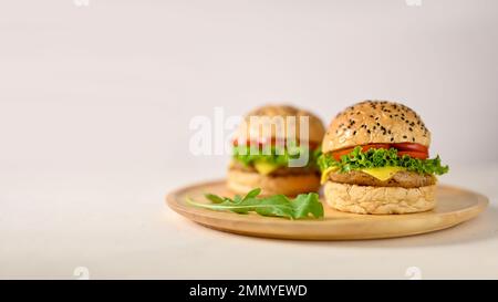 Tasty delicious beef burgers on wooden plate on white background with empty space. close-up image Stock Photo