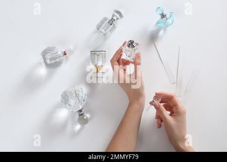 Woman applying perfume on white background, top view Stock Photo