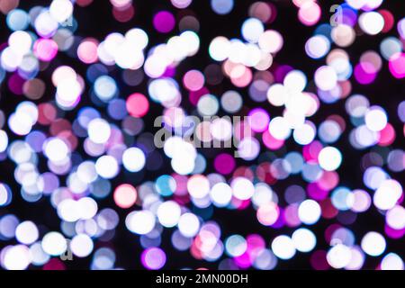 Defocussed background image of white, purple and grey lights on the black backdrop Stock Photo