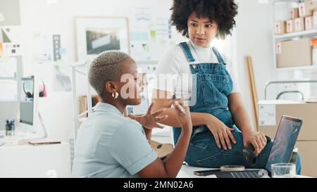 Warehouse, logistics and teamwork black women on laptop talking, discussion and conversation on e-commerce delivery system. Communication of delivery Stock Photo