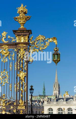 France, Meurthe et Moselle, Nancy, ironwork made of wrought iron of the fence and street lamp by Jean Lamour on Place Stanislas (Stanislas square former royal square) built by Stanislas Leszczynski, King of Poland and last Duke of Lorraine in the 18th century, listed as World Heritage by UNESCO, belfry of Saint Epvre basilica in neo classical style in the background Stock Photo