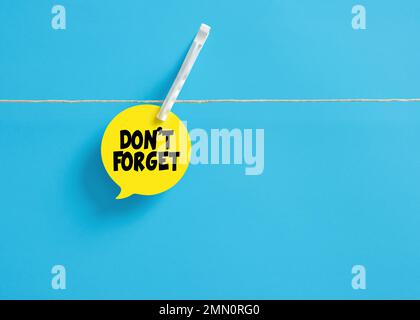 Don't forget message reminder on a speech bubble hanging on clothesline with a clothespin. Stock Photo