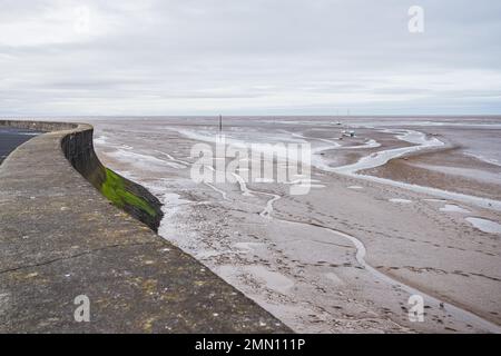 Bending promenade and sea wall at Meols on the Wirral seen at low tide in winter. Stock Photo