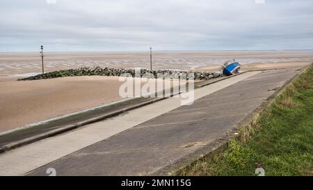 An abandoned boat seen on the slanted concrete sea shore at Meols on the Wirral seen in January 2023. Stock Photo