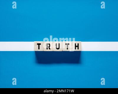 The word truth on wooden cubes on blue white background. Discovering the truth concept. Stock Photo