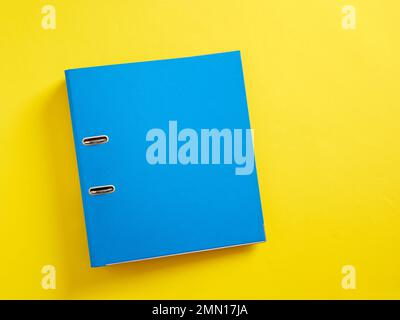Blue office folder on yellow background. Stock Photo