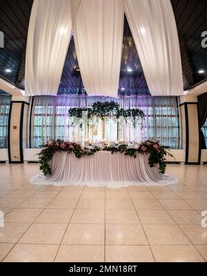 Wedding flowers set up in a restaurant. A wedding colorful bouquet arrangement on the table with white table cloth. High quality photo Stock Photo