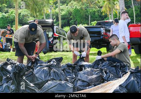 Airmen with the Airman Leadership School tie trash bags at Tanguisson Beach, Dededo on Sept. 24, 2022. ALS at Andersen AFB has incorporated a new squadron mentorship program allowing squadrons to guide the future Staff Sergeants throughout their five week course. The squadron mentors accompanied the students during their community service project to participate and build comradery. Stock Photo