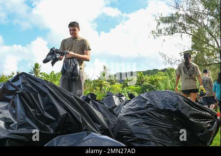 Airmen with the Airman Leadership School tie trash bags at Tanguisson Beach, Dededo on Sept. 24, 2022. ALS at Andersen AFB has incorporated a new squadron mentorship program allowing squadrons to guide the future Staff Sergeants throughout their five week course. The squadron mentors accompanied the students during their community service project to participate and build comradery. Stock Photo