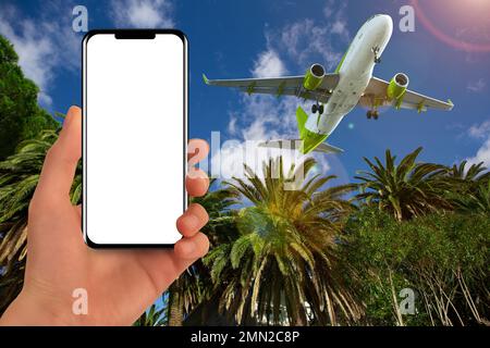 Hand with a phone on the background of an airplane in the sky. White screen, you can add your content Stock Photo