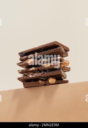 Stack of chocolate with nuts on a beige background Stock Photo