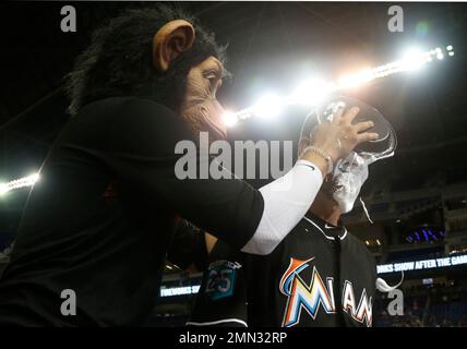 Miami Marlins' Miguel Rojas, wearing a mask, and Derek Dietrich