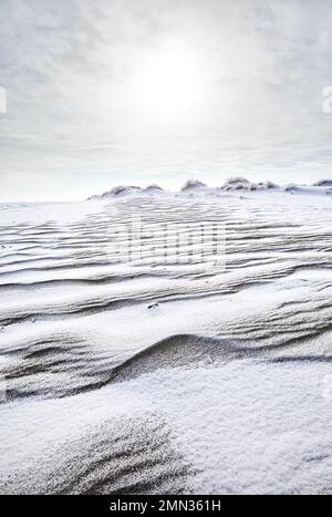 Surreal landscape of Ripple wave of sand dune covered with snow in the desert in Kazakhstan at winter Stock Photo
