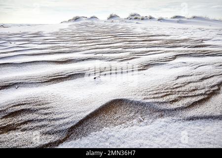 Surreal landscape of Ripple wave of sand dune covered with snow in the desert in Kazakhstan at winter Stock Photo