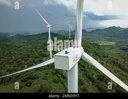 Two wind turbine technicians work on the nacelle of a turbine in the Sidrap Wind Farm area in South Sulawesi, Indonesia. Stock Photo