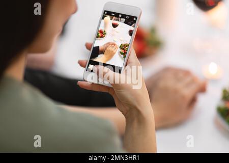 Woman taking photo while holding her fiance hand Stock Photo