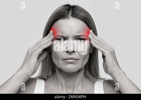 Woman suffering from headache, touching her temples Stock Photo