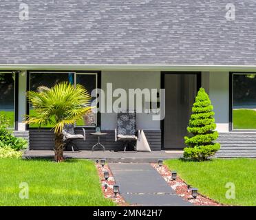 Main entrance of residential house with concrete pathway on bright sunny day Stock Photo