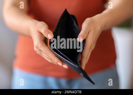 Poverty Concept. Unrecognizable Woman Showing Empty Wallet At Camera Stock Photo